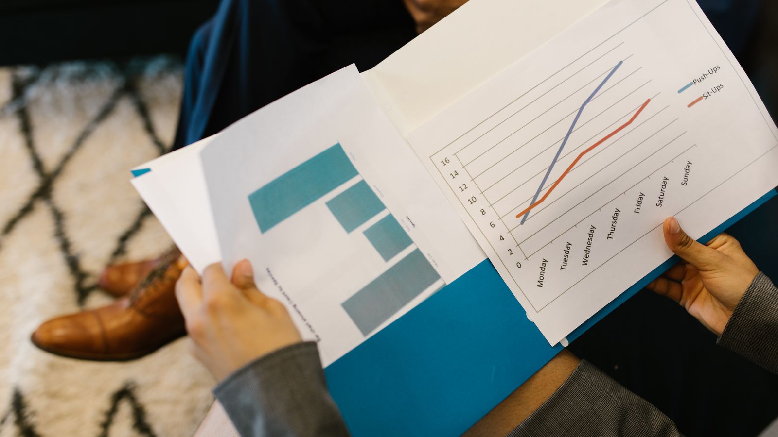Company reports and financial statements open on a table during a meeting