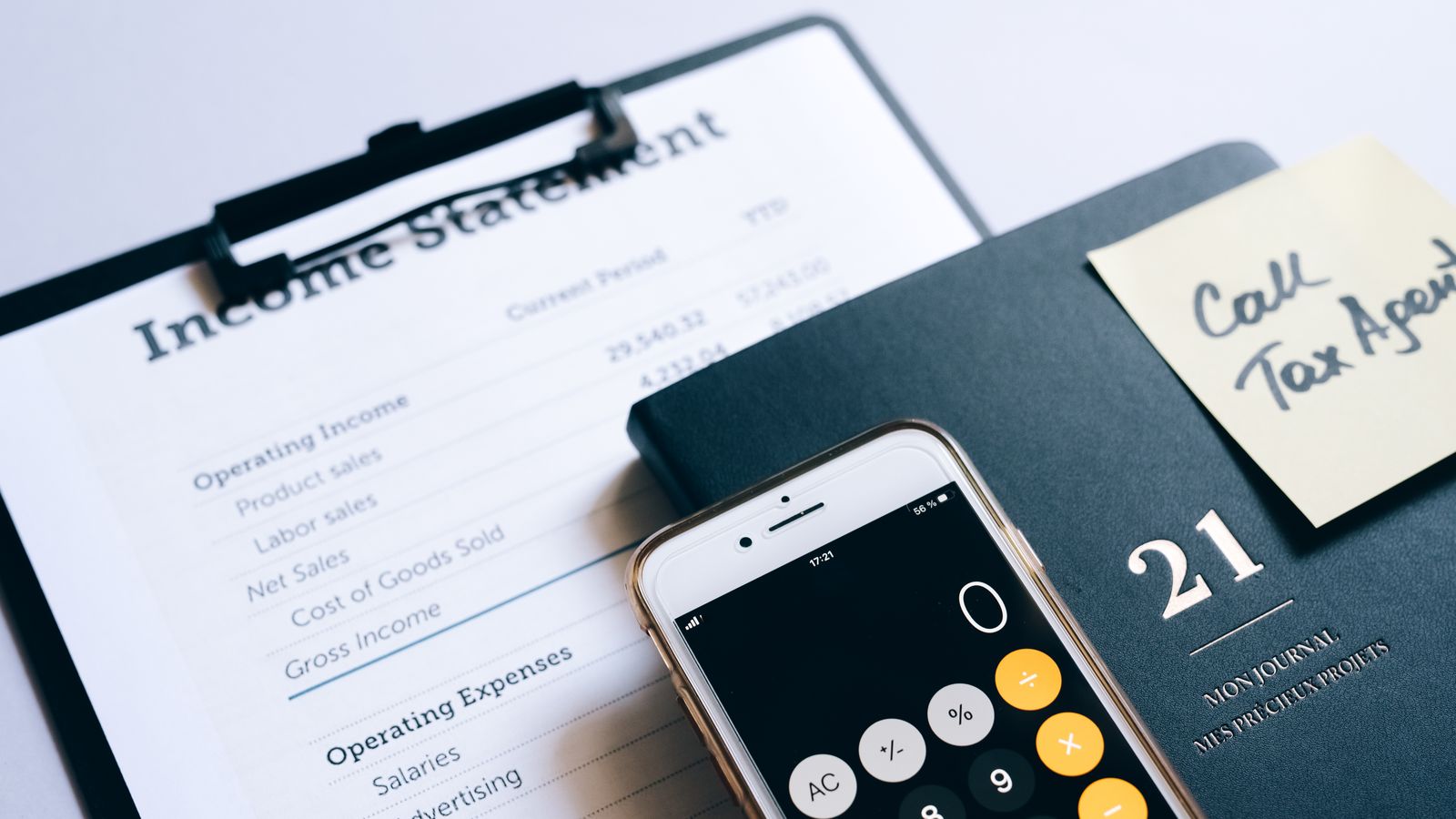 An income statement, a calculator and a planner on a desk