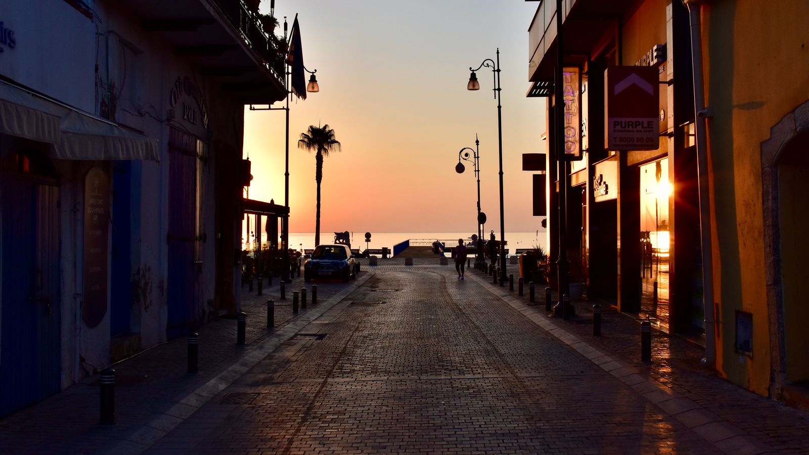 Street in Larnaca, Cyprus at sunset with the sea in the background
