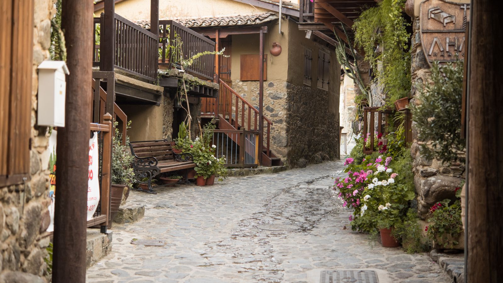 Cobbled village alleyway with flowers and benches in Kakopetria, Cyprus