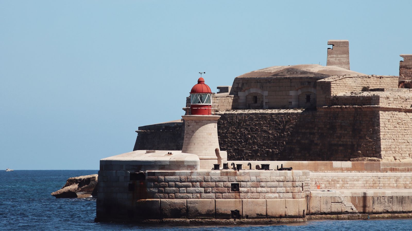 Lighthouse and fortifications on the seafront at Valletta, Malta