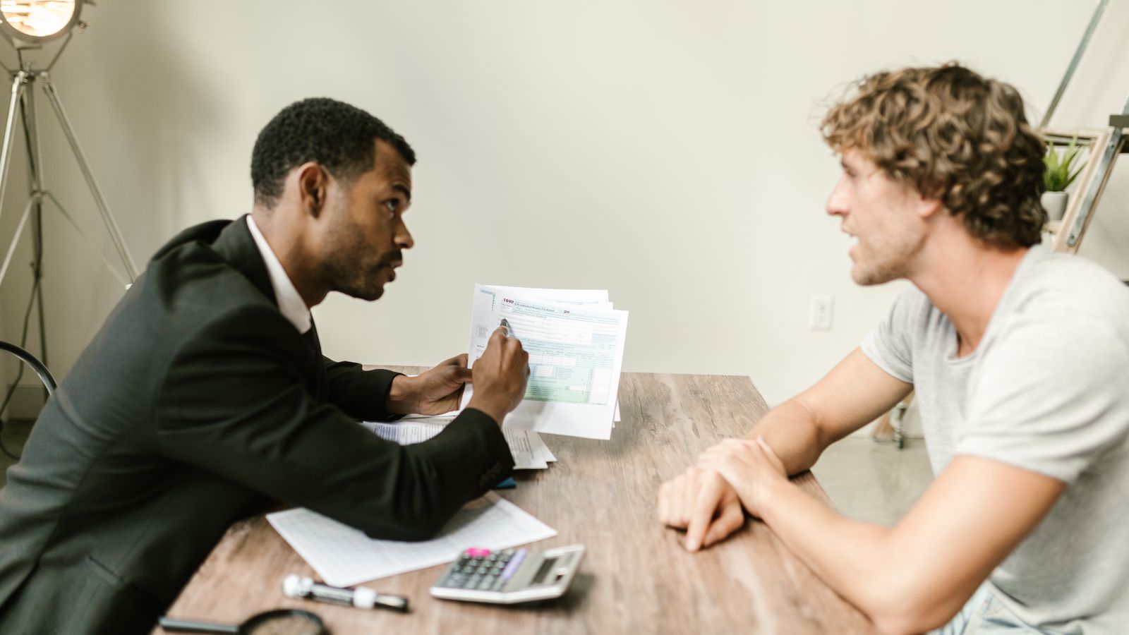 An accountant going through paperwork with a client across a desk