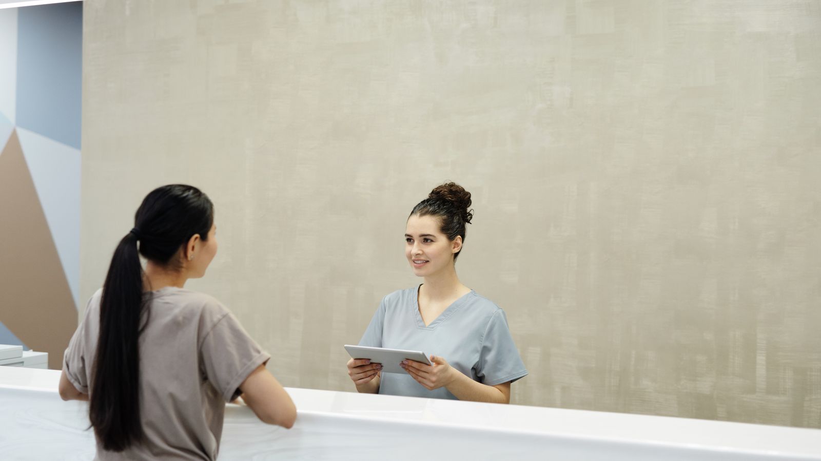 Patient being checked in at a medical clinic reception desk