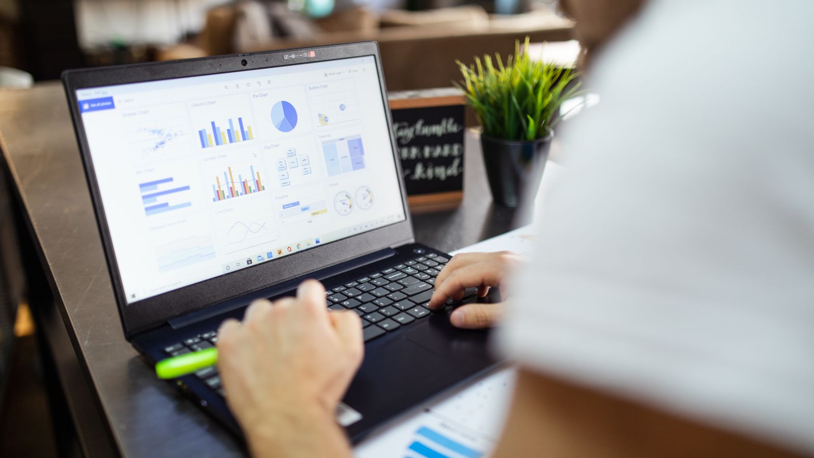 Laptop showing data and charts being checked in an office