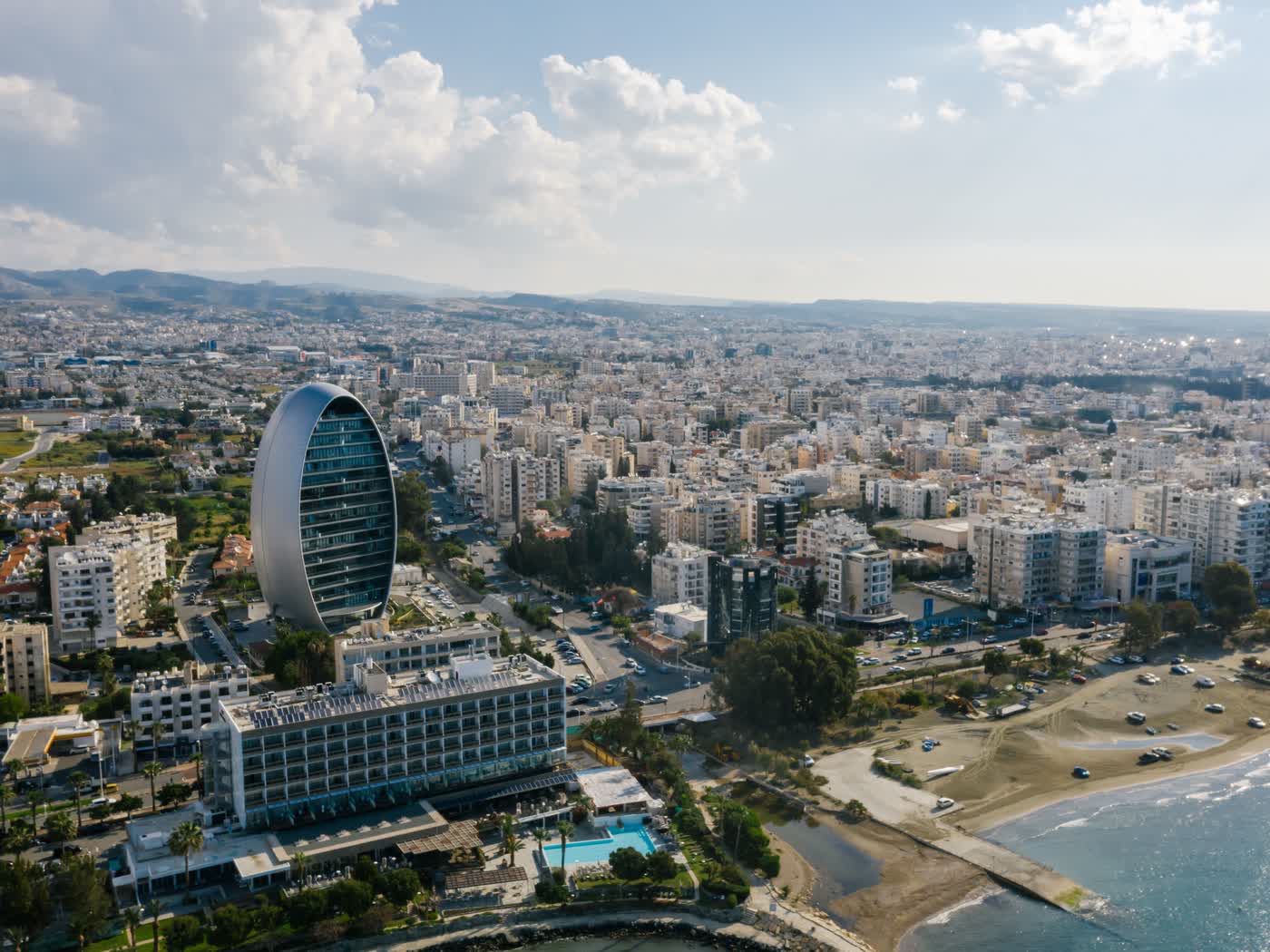 The Limassol skyline from the air, apartment blocks and the oval tower running back from the beach