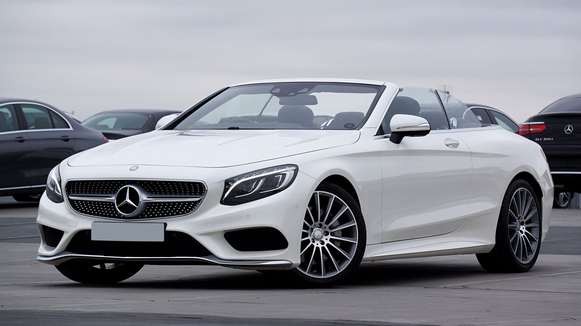A white Mercedes-Benz convertible parked outdoors in bright Cyprus sunshine